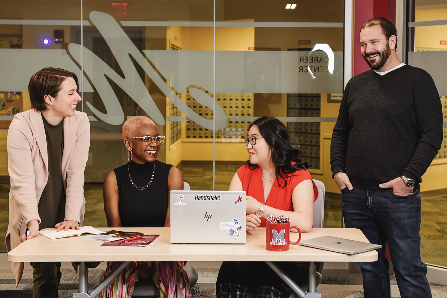 Four people having a discussion together in a office space.