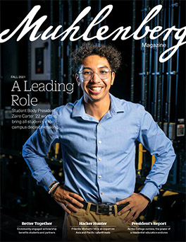 A magazine cover that says Muhlenberg Magazine with a photo of a college student in a blue shirt smiling for the camera
