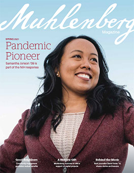 A magazine cover that says Muhlenberg Magazine with a portrait of a young woman in a maroon blazer