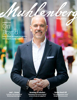 A magazine cover that says Muhlenberg Magazine with a photo of a man in a dark suit