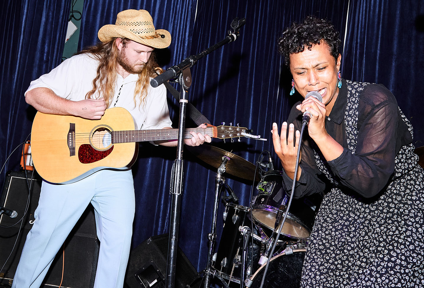 A guitarist and singer perform on stage