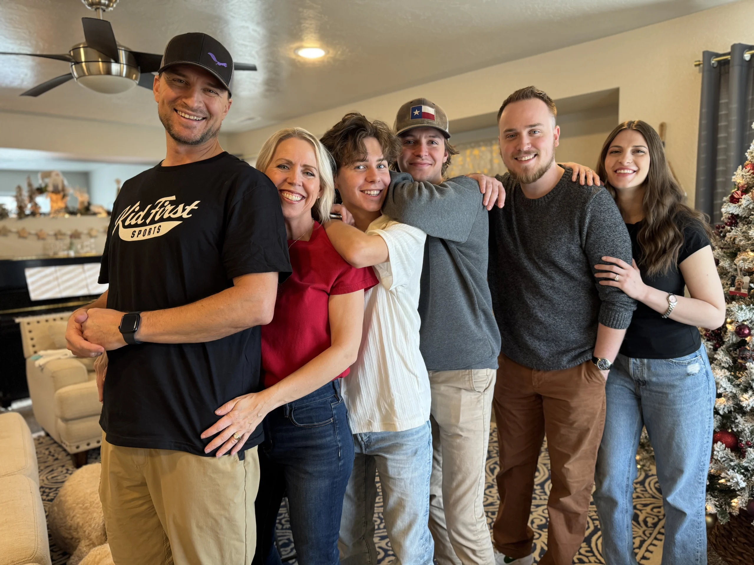 Six people pose for a photo inside a home