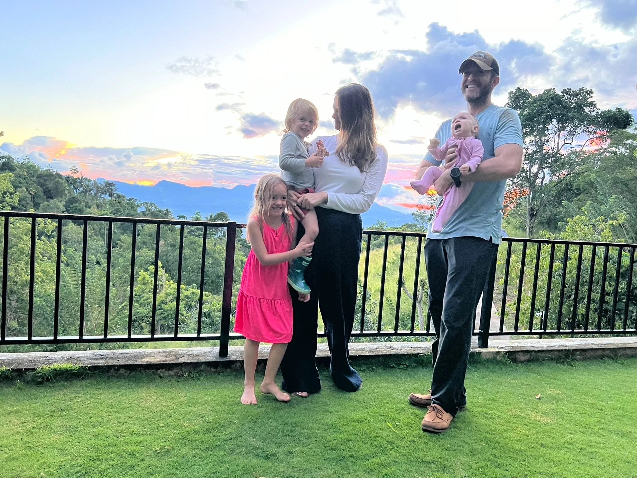 Two parents and three small children pose for a photo outside