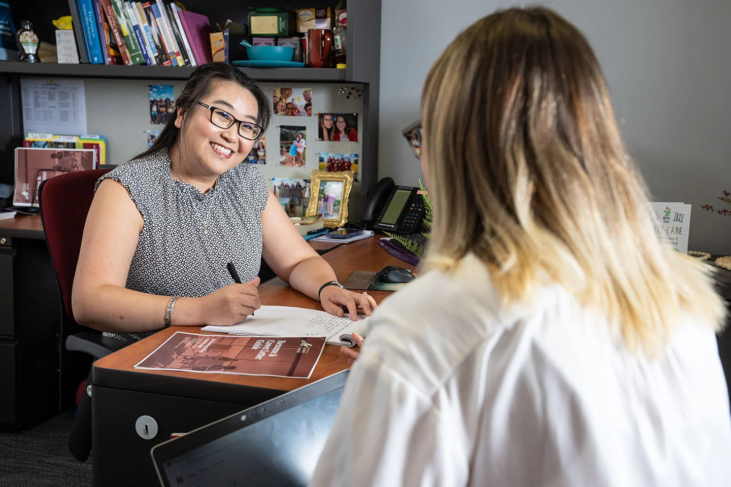 A career counselor smiles at the student she's sitting with in her office